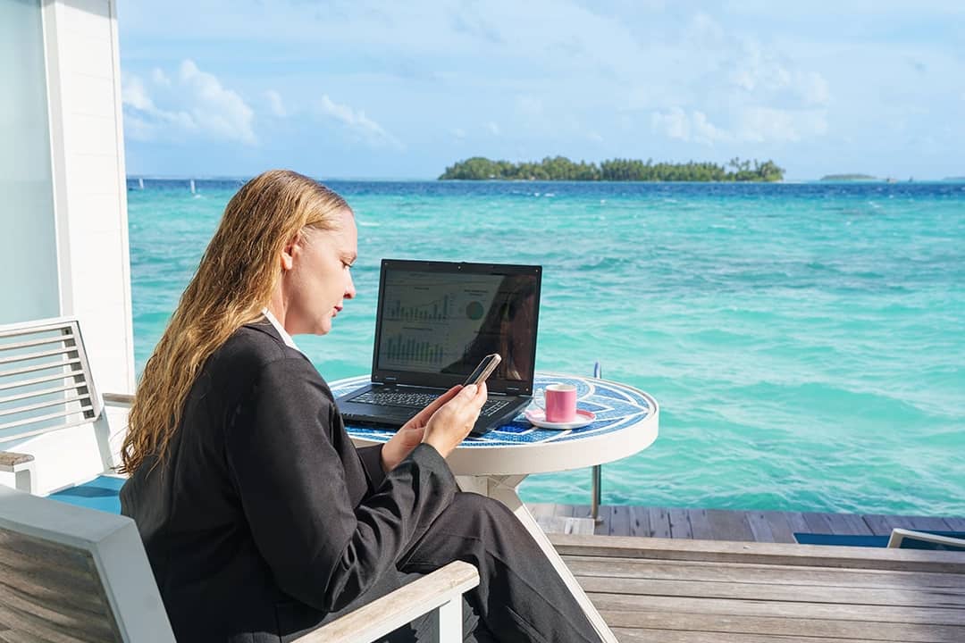 A young woman checking at dashboards and email while on a beach vacation.